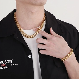 Men's polished gold Cuban link chain necklace and bracelet set worn by a model