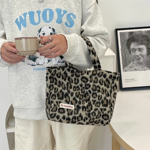 Detail of plush leopard print tote bag with soft texture and white brand label