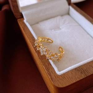 Detail of gold-plated adjustable ring with star-shaped zircons on a luxury wood box