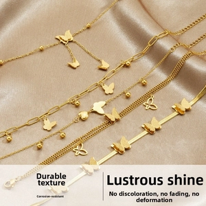 Detailed macro of gold butterfly charm bracelet set with matte texture on satin background