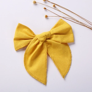 Close-up of yellow cotton linen bow hair clip with detailed fabric texture and stitching