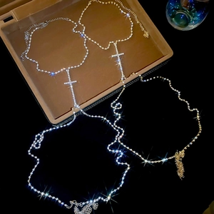 Detail showing cross pendant body chain with shimmering crystals and adjustable lobster clasp