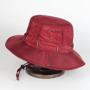 Detail of burgundy outdoor bucket hat with metal eyelets and adjustable windproof cord