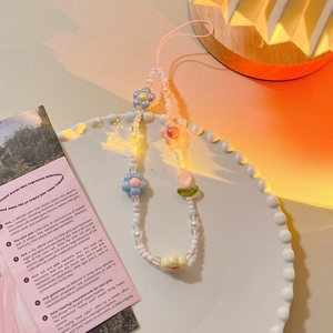 Close-up of beaded tulip flower and heart charms on a pink aesthetic phone strap