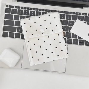 Detailed shot of a polka dot canvas pouch with snap button closure on a laptop
