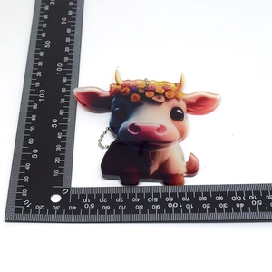 Cartoon cow acrylic pendant shown with a measurement scale for precise 6x6cm sizing details