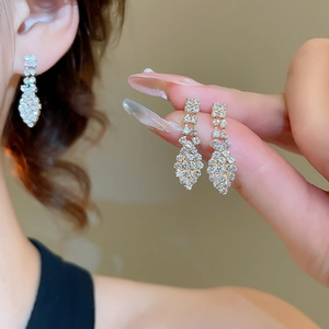 Detail of silver long tassel earrings with sparkling rhinestones and drop design