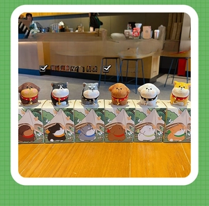 Close-up of six assorted resin puppy figurines with tiny bells on colorful boxes