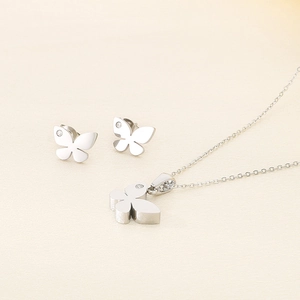 Detailed view of silver butterfly pendant necklace and earrings set with tiny crystals