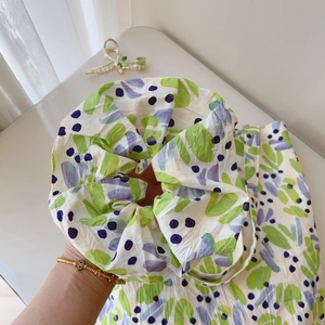 Detail of floral printed cotton tote bag with matching scrunchie in green and purple
