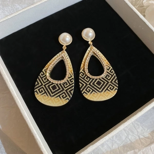Detailansicht tropfenförmiger Ohrringe mit Perlen, Strass und geometrischen Mustern