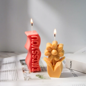 Detailweergave van de handgemaakte kaars met I MISS YOU reliëf en een floraal margrietontwerp
