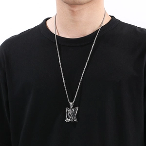 Close-up of a silver gothic grim reaper pendant on a male model with black t-shirt