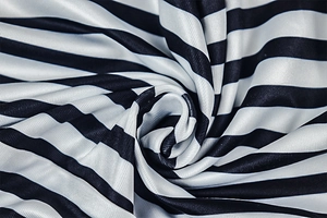 Detail shot of soft black and white striped knit fabric with elegant draped texture