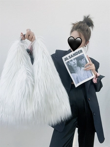 Fashionable model holding a white faux fur tote bag showing soft plush texture and Y2K style