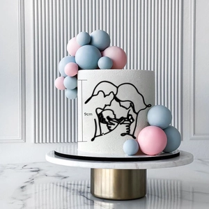 Close-up of a 9cm black acrylic baby shower cake topper with a family line art design