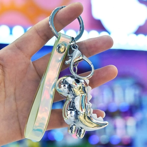 Macro view of shiny silver dinosaur keychain with iridescent strap and lobster clasp