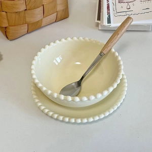 Creamy ceramic bowl and plate set with elegant beaded edges in a cozy ins-style setting