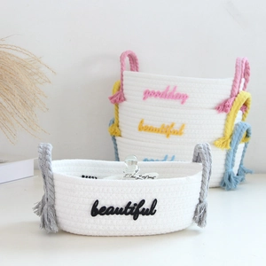 Detail of colorful woven handles on white cotton rope storage baskets in multiple sizes