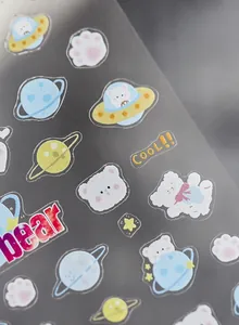 Macro shot of space bear nail stickers featuring astronauts and colorful planets