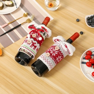 Christmas knitted wine bottle covers with deer and snowflake patterns on a festive table