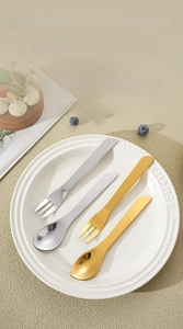 Polished stainless steel dessert spoons and forks set on a white ceramic plate