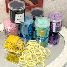 Colorful high-elasticity scrunchies in a clear storage jar with mirrored background