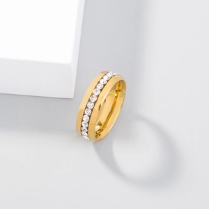Macro shot of a golden ring with embedded clear crystals on a minimalist white display