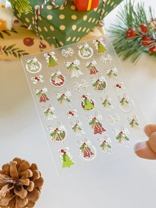 Detail of Christmas nail art stickers featuring 3D embossed trees, bells, and wreaths