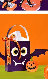 Close-up of purple bat-themed gift bags and pumpkin boxes with Halloween ribbons