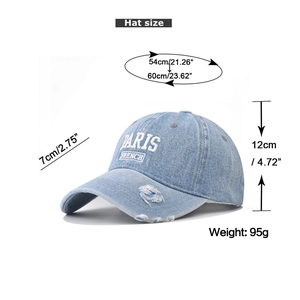 Detailed view of washed denim baseball cap with PARIS embroidery and size specifications