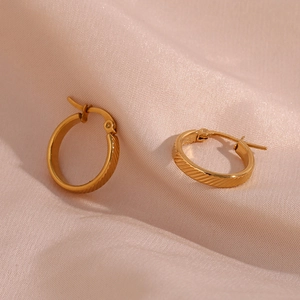Detail of 20mm gold-plated stainless steel hoop earrings with elegant diagonal textures