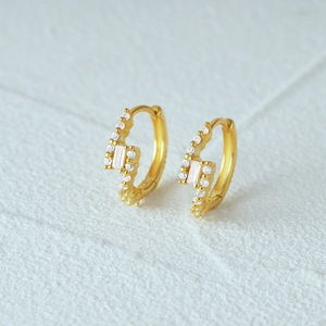 Macro shot of gold lightning bolt hoop earrings with sparkling cubic zirconia stones