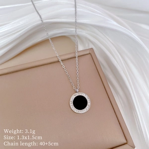 Macro shot of titanium steel necklace with black agate pendant and crystal inlay details
