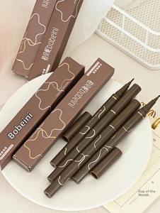 Detail view of 0.05mm ultra-fine liquid eyeliner pens with sleek golden patterned packaging