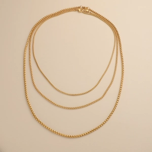 Detailed view of three gold-colored stainless steel box chains in varying lengths