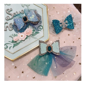 Three glittery bow hair clips with tulle and rhinestones on star-patterned background