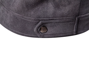 Detailed macro view of gray faux suede fabric with decorative strap and metal button