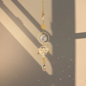 Macro view of crystal prism suncatcher with brass butterfly casting rainbow shadows