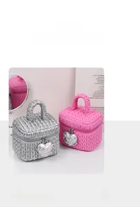 Detail of silver and pink quilted cosmetic bags with heart charms and matelassé texture