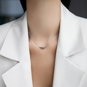 Detailed view of 925 sterling silver leaf bracelet on model with elegant minimalist style