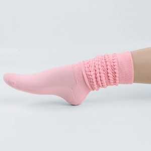Detail showing bright pink slouch socks with ribbed knit texture and stylish folds