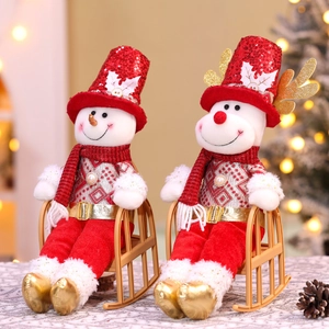 Detailed view of plush Christmas snowman and reindeer dolls sitting on a gold rocking chair