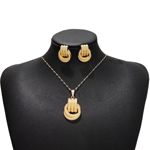 Detailed view of gold multi-ring textured necklace and stud earring set on a black mannequin