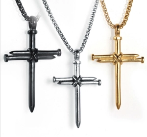 Detailed view of three nail cross necklaces in black, silver, and gold metal finishes