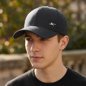 Classic black cotton baseball cap with silver metal logo worn by male model outdoors