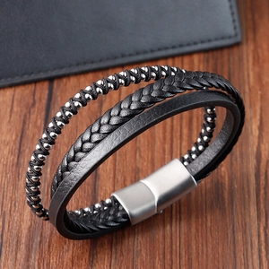 Close-up of multi-layer black braided leather bracelet with silver beads and magnetic clasp