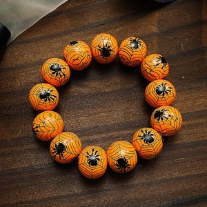 Gros plan du bracelet d'Halloween avec perles oranges et motifs de toile d'araignée noirs