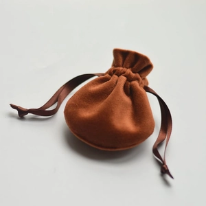 Detailed close-up of brown velvet drawstring pouch texture with soft satin ribbon