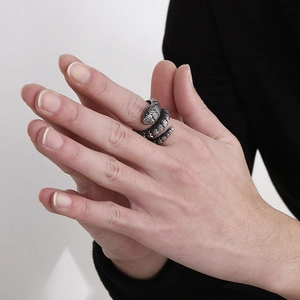 Close-up of silver snake ring with detailed scale texture on person's hand